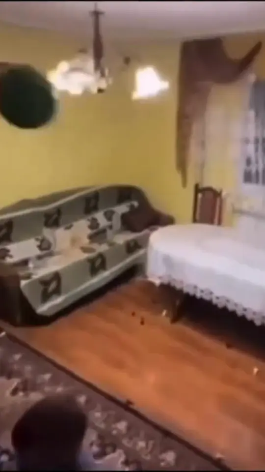 Someone swings hard at a target in a cluttered living room