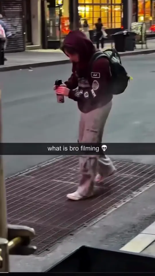 A walker crosses a lit night street moments before the haircut reveal