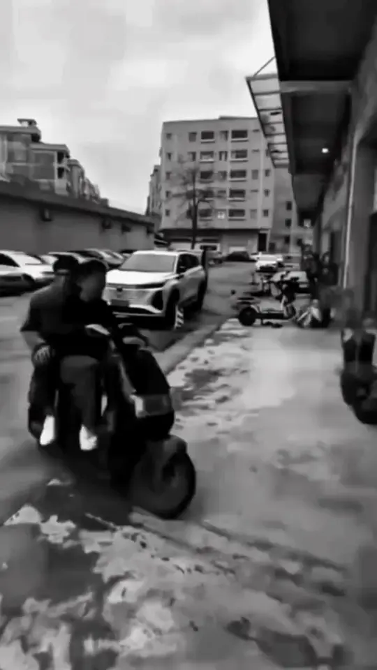 A scooter carves through a wet grey street before the scene flips